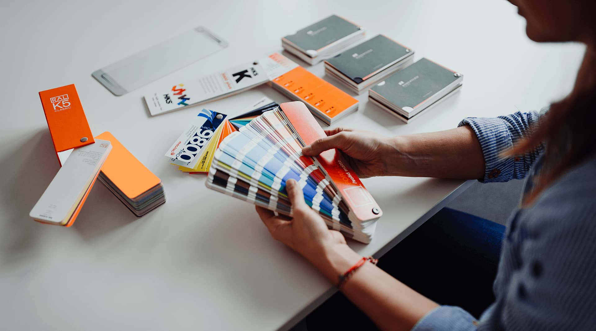 Ein Agentur Mitarbeiter wählt die Corporate Design Farben in einem Farbfächer aus